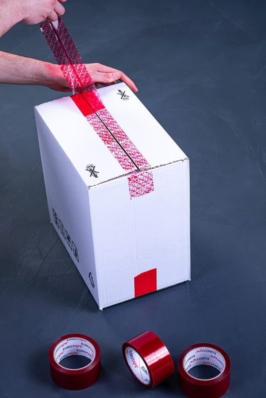 Biały karton oklejany czerwoną taśmą