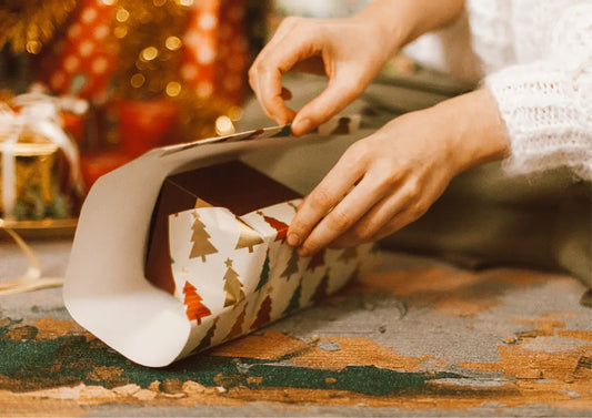 pakowanie paczki świątecznej w pakier w choinki z taśmą klejącą z nadrukiem świątecznym