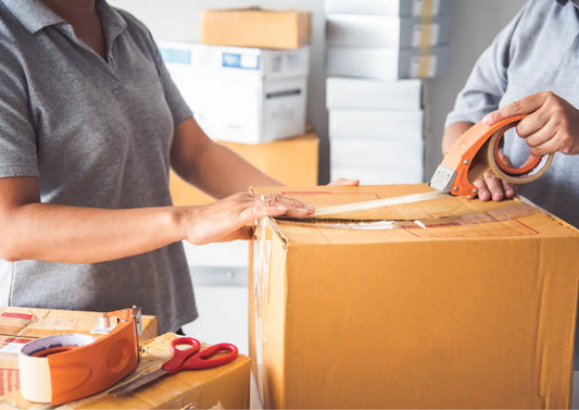 pakowanie paczki kartonowej z taśmą pakową