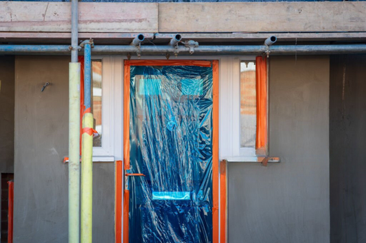 remont budynku - drzwi na budowie zabezpieczone taśmą przed brudem i uszkodzeniem